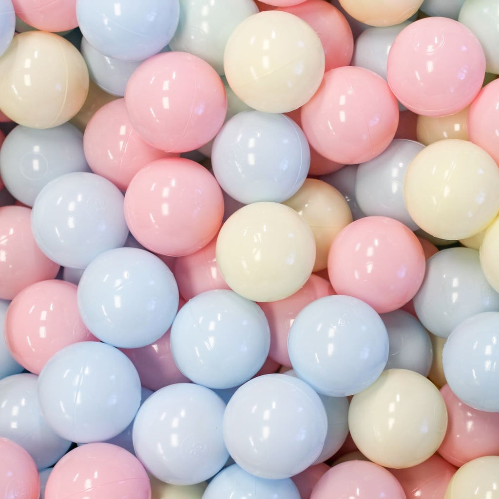 Close-up of numerous shiny pastel-colored plastic ball pit balls. Spheres fill the frame, reflecting light on their surfaces